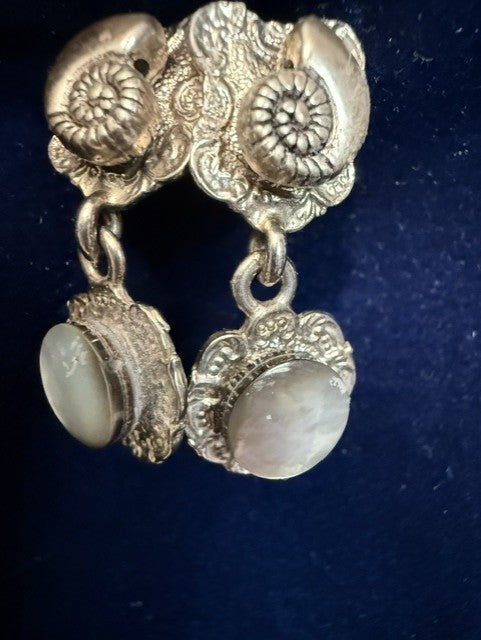 Handmade Seaside Dream earrings — ornate silver-tone nautilus shell tops with luminous mother of pearl button drops against a dark blue background