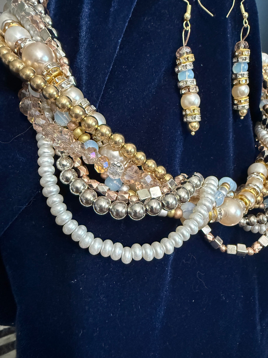 Close-up detail of the Grande Luxe Multi-Strand Celebration Set — freshwater pearls, champagne crystals, rhinestone rondelles and gold metallic beads on navy velvet