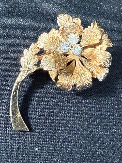 Vintage Coro 12kt gold filled flower brooch with textured dimensional petals and light blue rhinestone center