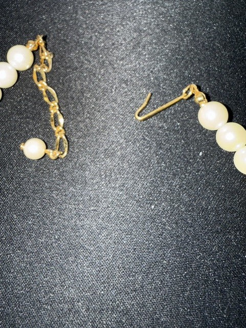 Gold-tone hook clasp and pearl-tipped extension chain detail