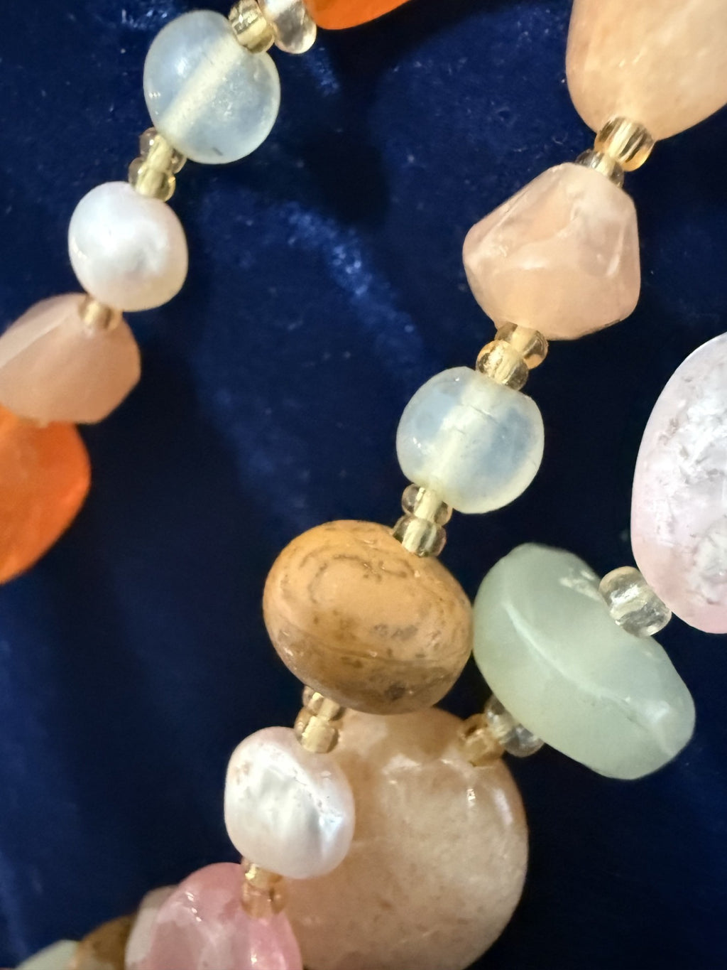 Macro detail — burlwood rounds, aquamarine, carnelian and pearl beads with gold spacers