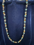 Close-up of teal natural stone and gold metallic crystal rondelle beads