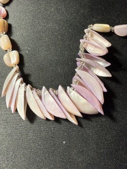 Close-up of cascading shell petal fringe centerpiece showing lavender and blush tones