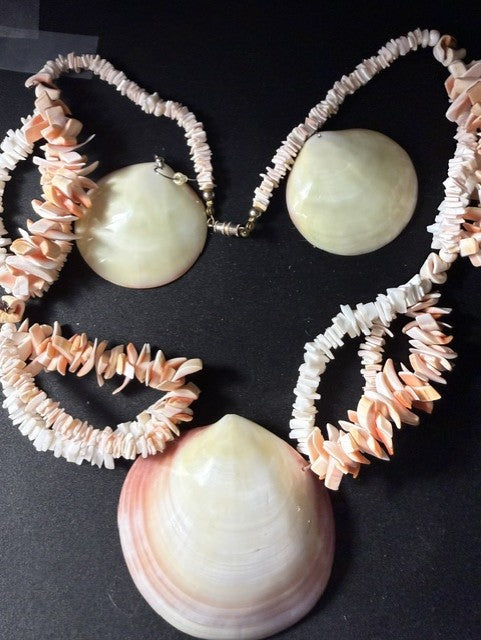 Earrings and necklace strands close-up showing domed clam shell earrings