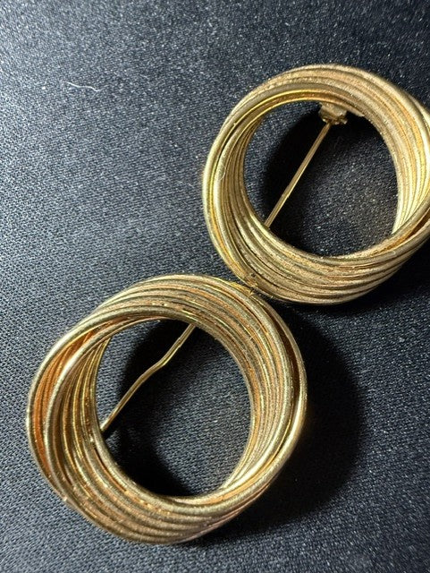 Matching pair of vintage gold-tone circular swirl brooches — front view showing multi-wire wrapped ring design