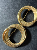 Matching pair of vintage gold-tone circular swirl brooches — front view showing multi-wire wrapped ring design