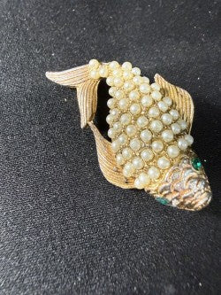 Close-up of pearl cabochon scales and emerald rhinestone eye on koi brooch