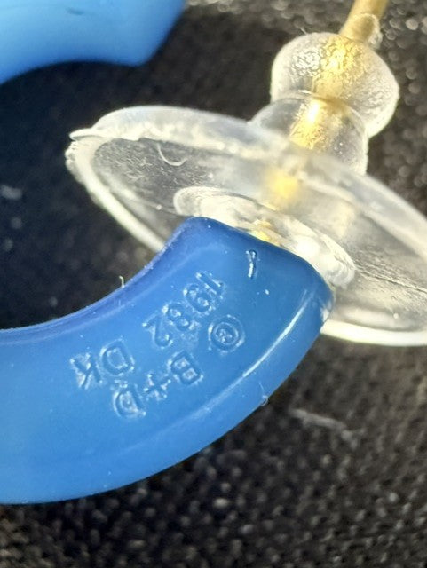 Close-up of B+D 1982 DK marking on blue lucite hoop earring