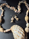 Close-up of spiral snail shell beads and mixed shell beads on necklace