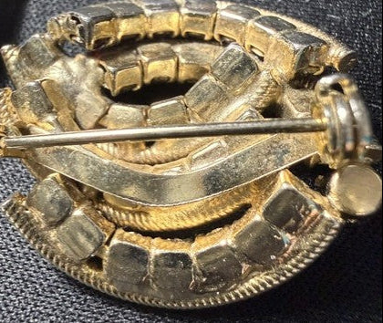 Back of Trifari brooch showing pin closure and signed mark