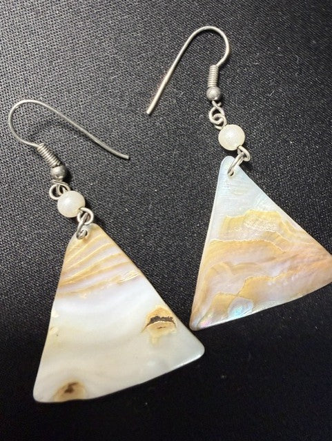 Close-up of mother-of-pearl triangle earrings showing iridescent surface detail