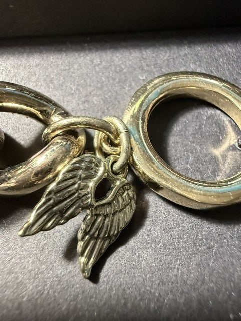 Close-up of angel wing charm on toggle clasp of Victoria's Secret bracelet