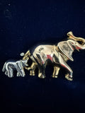 Vintage Liz Claiborne two-elephant brooch front view showing gold-tone and silver-tone elephants with trunks up