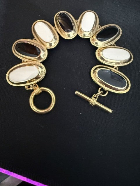 Gold tone black and white oval cabochon link bracelet with toggle clasp