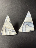 Pair of triangular natural shell stud earrings in grey and lavender, flat lay