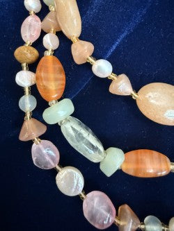 Detail of carnelian, rose quartz and aquamarine beads with gold-tone spacers