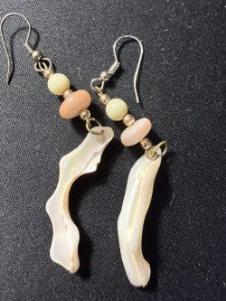 Close-up of mother-of-pearl shell stick earrings showing natural iridescent luster and bead stack