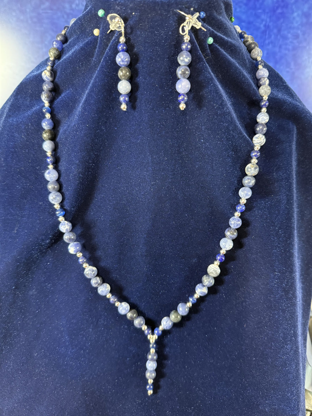 Sodalite, blue spot jasper and navy blue cat’s-eye Y-drop necklace with matching earrings on a navy display bust