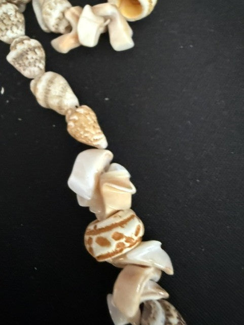 Close-up of orange and white patterned cone shell accent beads