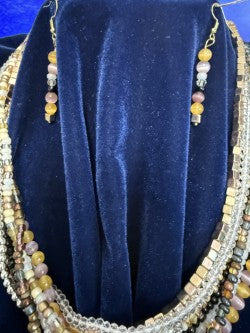 Coordinating beaded earrings with gold-plated hooks displayed beside the multistrand necklace