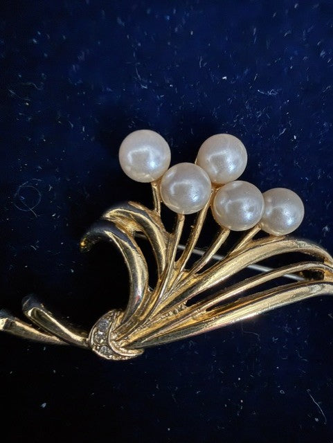 Vintage gold-tone faux pearl spray brooch angled front view showing rhinestone accents