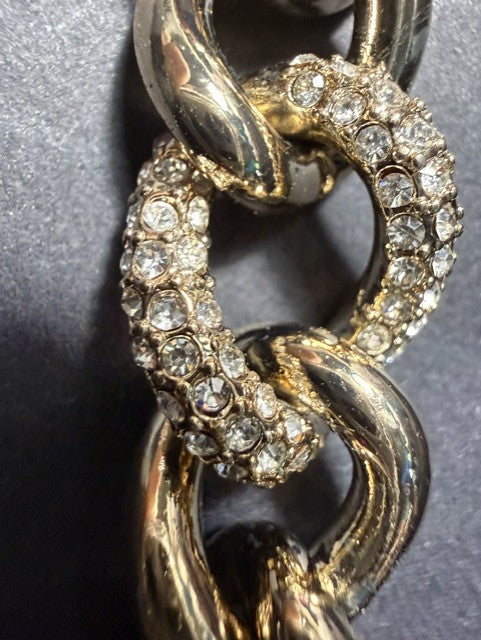 Close-up of pavé rhinestone-encrusted links on Victoria's Secret gold-tone bracelet