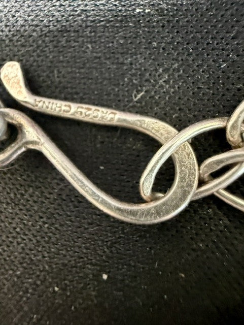 Close-up of DR925 China stamp on sterling silver S-hook clasp of Jay King sodalite necklace