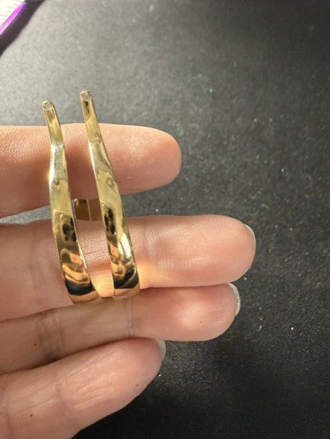 High-polish gold-tone half-hoop earrings showing hammered curve detail