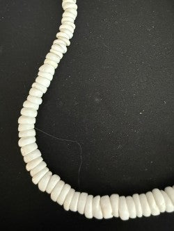 Full length view of white puka disc shell necklace