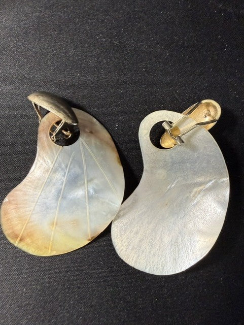 Side view of vintage mother-of-pearl clip-on earrings showing shell shape and clip hardware