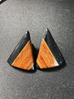 Front view of black resin and wood triangle earrings showing warm wood grain inlay