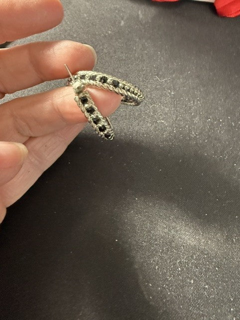 Side view of silver-tone twisted rope hoop earring showing depth and curve