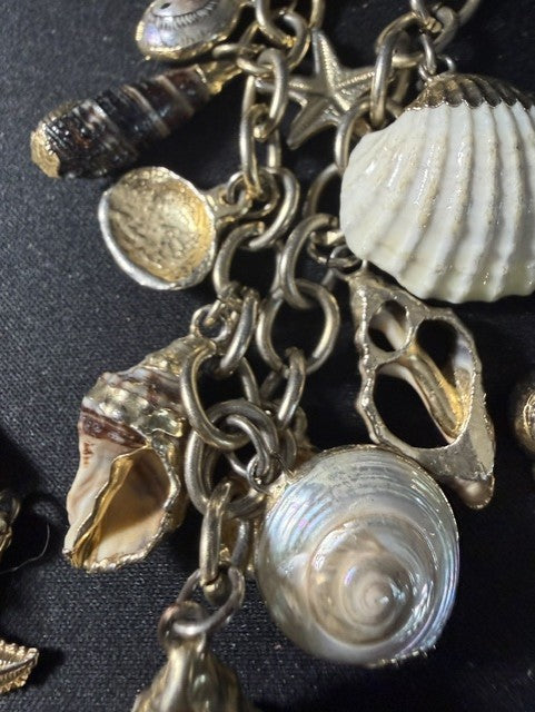 Close-up of real shell charms including scallop, turban snail, oyster and starfish on gold chain
