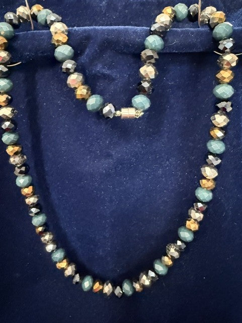 Full view of teal stone and gold crystal rondelle necklace on blue velvet