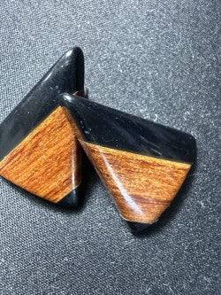 Black resin and wood inlay triangle stud earrings showing bold geometric design