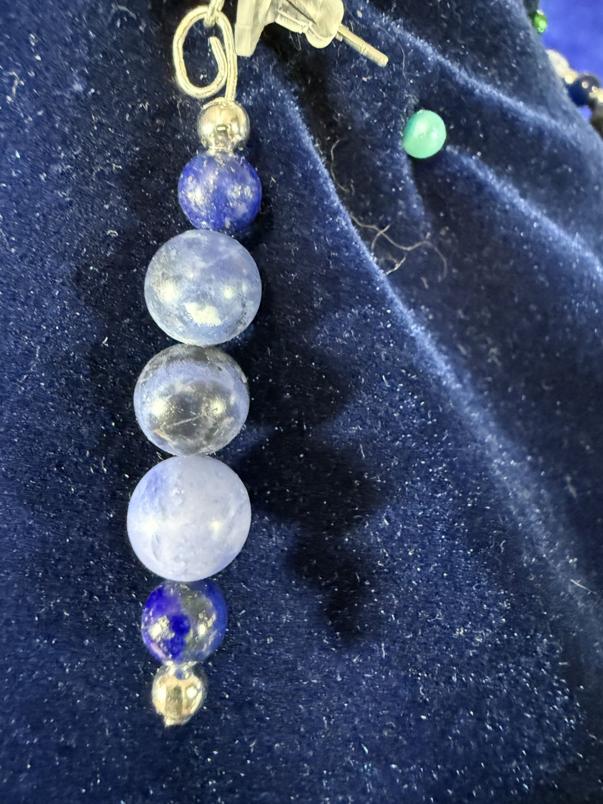 Close-up of a matching earring with sodalite, blue spot jasper and navy blue cat’s-eye beads