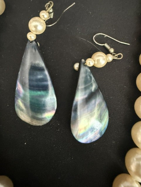 Detail of matching iridescent shell drop earrings on silver hooks