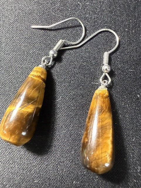 Close-up of tiger eye teardrop earrings showing natural stone shimmer and silver-tone hooks