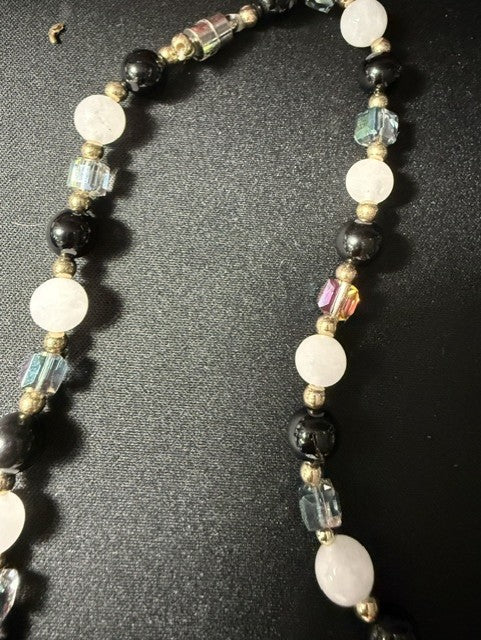 Detail shot of peacock iridescent glass cubes and gold spacer beads