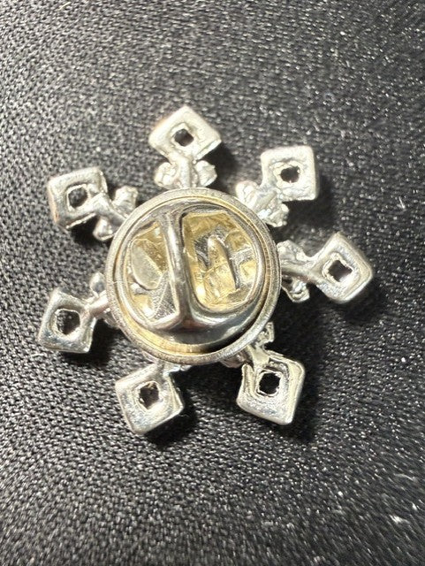 Vintage sterling silver snowflake pin back showing butterfly clutch