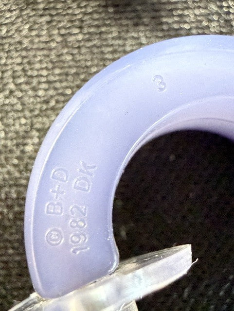 Close-up of B+D DK marking on periwinkle lucite hoop earring