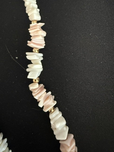 Close-up of pink and white shell chip necklace with gold spacer beads