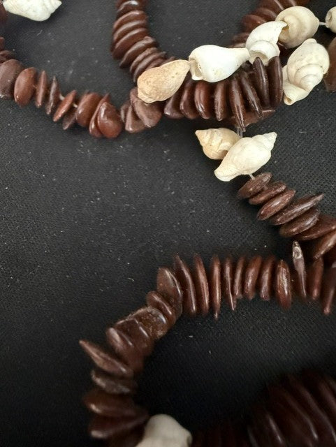Detail of dark brown kukui disc beads with white shell accents