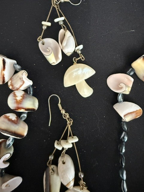 Close-up of graduated conch shells and carved Mother of Pearl mushroom earring pendant