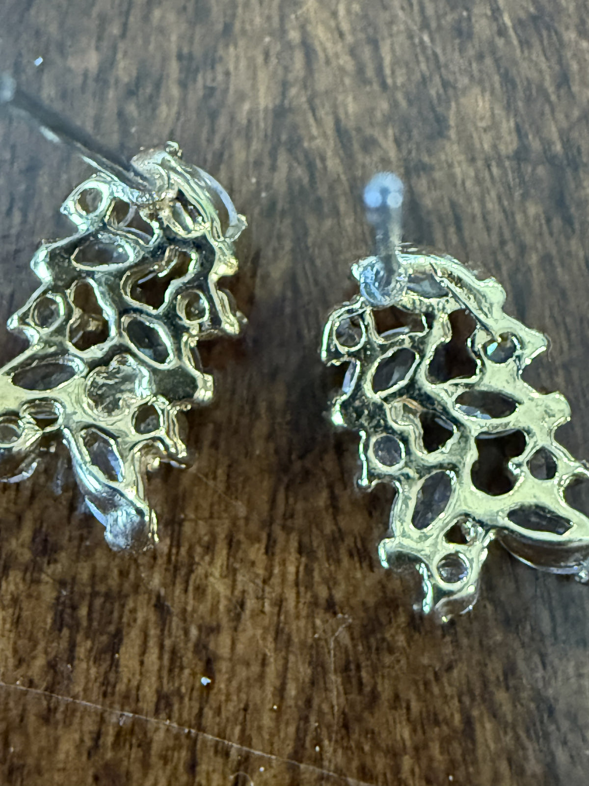 Back view of gold-tone marquise crystal cluster pierced earrings showing open lattice framework and silicone clutch backs
